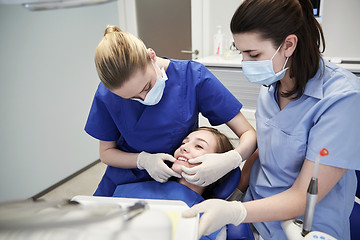 Image showing happy female dentist with patient girl at clinic