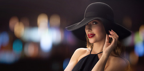 Image showing beautiful woman in black hat over night lights