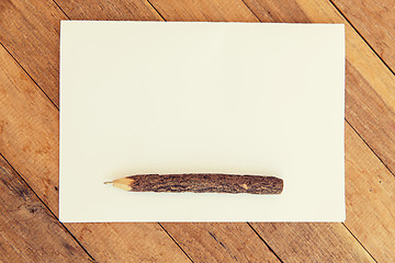 Image showing white blank paper sheet with wooden pen on table 