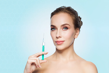 Image showing beautiful woman holding syringe with injection