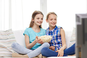 Image showing happy girls with popcorn watching tv at home