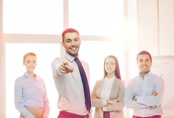 Image showing businessman in office pointing finger at you