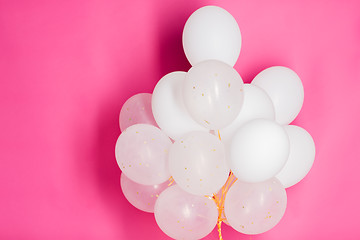 Image showing close up of white helium balloons over pink