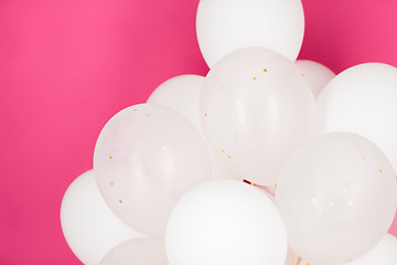 Image showing close up of white helium balloons over pink