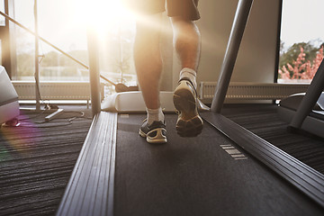Image showing close up of man legs walking on treadmill in gym