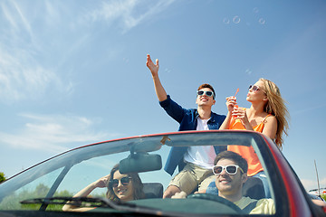 Image showing friends driving in car and blowing bubbles