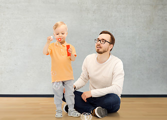 Image showing father with son blowing bubbles and having fun