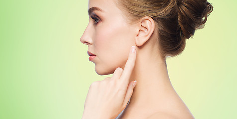 Image showing beautiful woman pointing finger to her ear