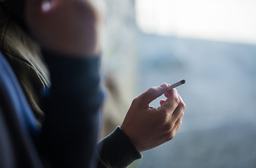 Image showing close up of male hand with smoking cigarette