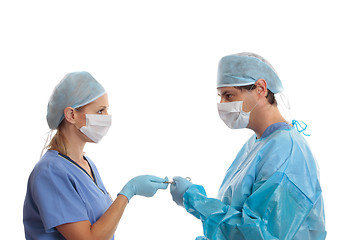 Image showing Scrub nurse handing surgeon forceps