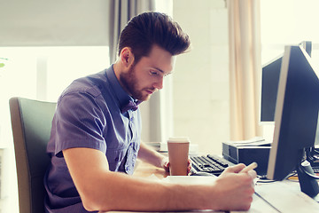 Image showing creative male office worker with coffee writing