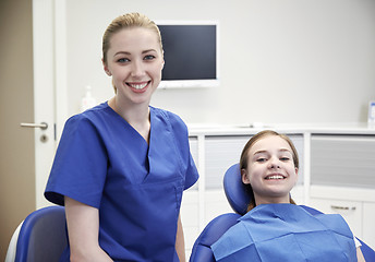 Image showing happy female dentist with patient girl at clinic