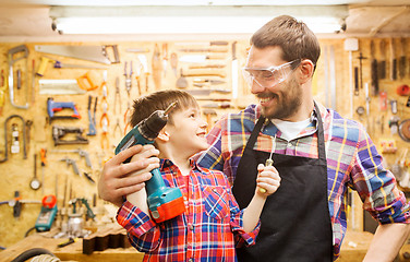 Image showing father and son with drill working at workshop