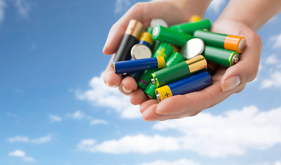 Image showing close up of hands holding alkaline batteries heap