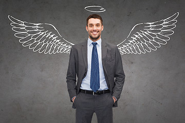 Image showing smiling businessman with angel wings and nimbus