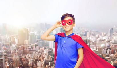 Image showing boy in red superhero cape and mask over city