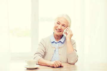 Image showing senior woman with smartphone calling at home