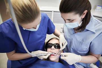 Image showing female dentists treating patient girl teeth