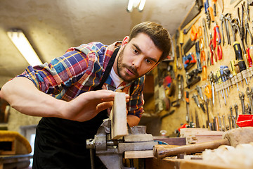 Image showing carpenter working with plane and wood at workshop