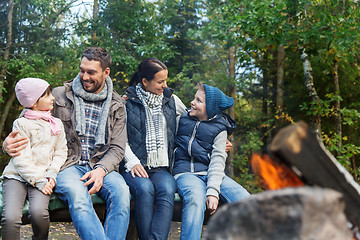 Image showing happy family sitting on bench at camp fire