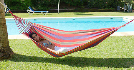 Image showing Woman in hammock at tropic resort with pool