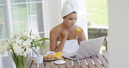 Image showing Woman in towel with laptop having breakfast