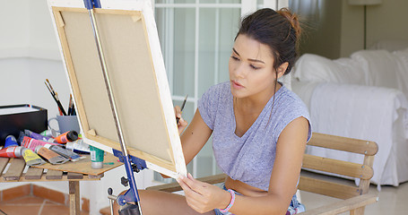 Image showing Attractive female artist working on a canvas