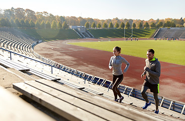 Image showing happy couple running upstairs on stadium