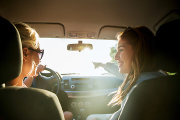 Image showing happy teenage girls or women in car at seaside