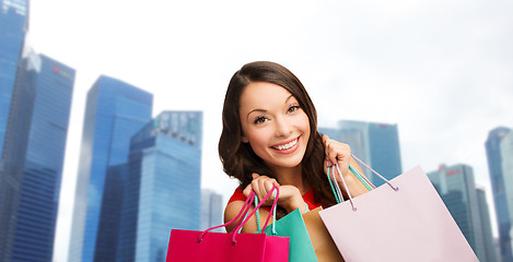 Image showing happy woman with shopping bags over singapore city