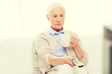 Image showing senior woman watching tv and drinking tea at home