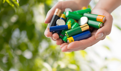 Image showing close up of hands holding alkaline batteries heap