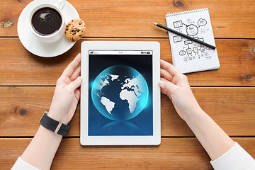 Image showing close up of woman with tablet pc on wooden table