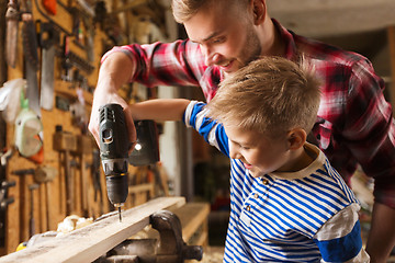 Image showing father and son with drill working at workshop