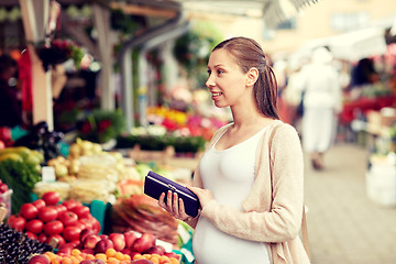 Image showing pregnant woman with wallet buying food at market