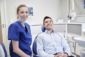Image showing happy female dentist with man patient at clinic