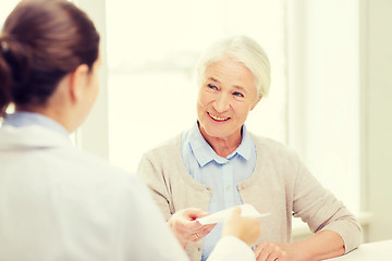 Image showing doctor giving prescription to senior woman