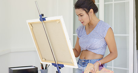 Image showing Artistic young woman working on a painting