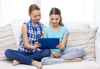 Image showing happy girls with tablet pc sitting on sofa at home