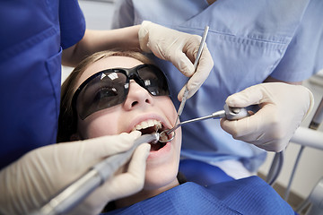 Image showing female dentists treating patient girl teeth