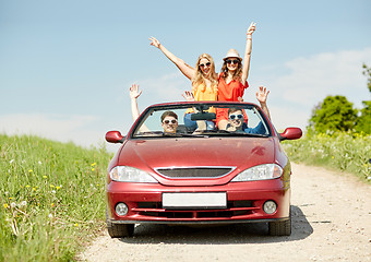 Image showing happy friends driving in cabriolet car at country