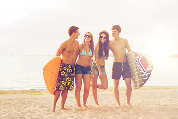 Image showing smiling friends in sunglasses with surfs on beach