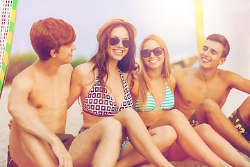 Image showing smiling friends in sunglasses with surfs on beach