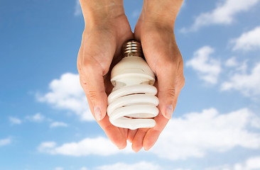 Image showing close up of hands holding energy saving lightbulb