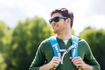 Image showing happy young man with backpack hiking outdoors