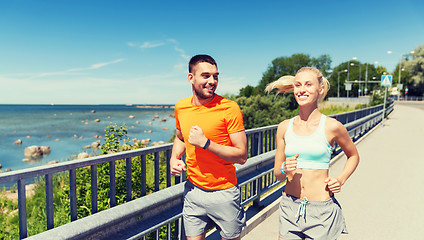 Image showing smiling couple running at summer seaside