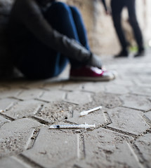 Image showing close up of addicts and drug syringes on ground