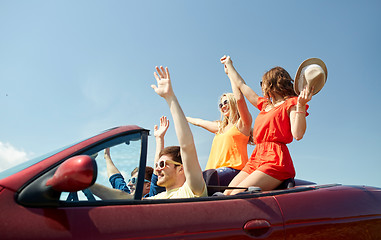 Image showing happy friends driving in cabriolet car at country