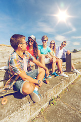 Image showing group of smiling friends sitting on city street