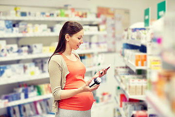 Image showing happy pregnant woman with smartphone at pharmacy